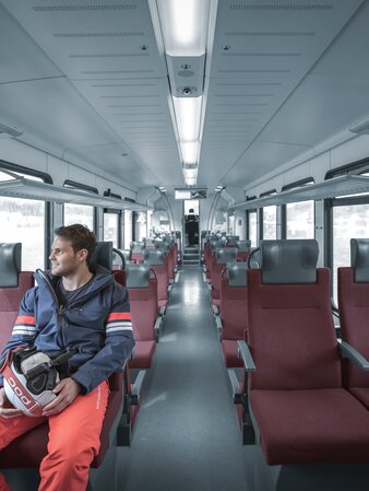 Man with skis in the train | © Manuel Kottersteger
